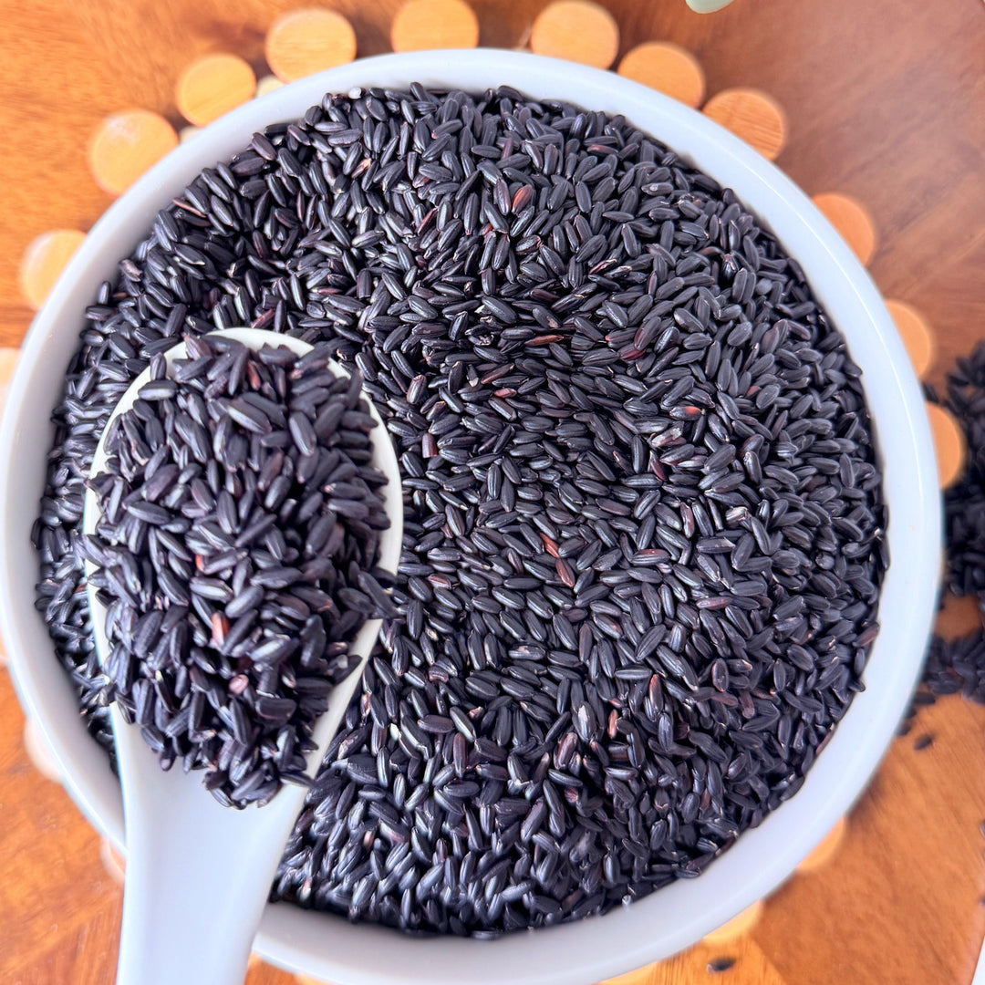 Certified organic black rice grains from Purely Organic Foods, showcasing deep purple-black color and natural whole grain texture, ideal for healthy meals