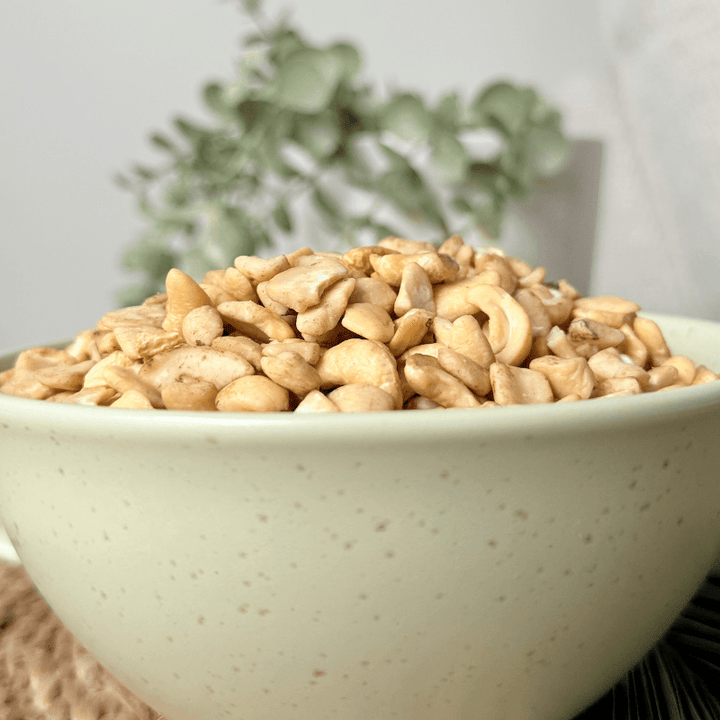 High-quality organic cashew nut pieces, sustainably sourced and minimally processed, displayed in a rustic kitchen setting for culinary inspiration."