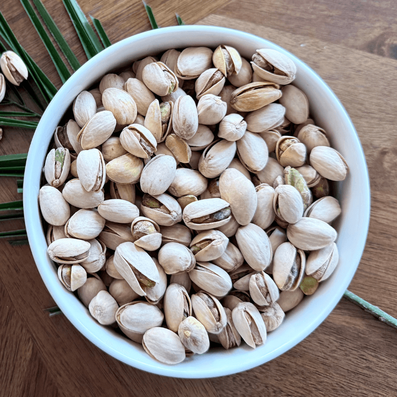 Purely Organic Foods roasted and salted organic pistachios in split shells, shown in a rustic bowl, perfect for healthy snacking and entertaining."

"Close-up of crunchy organic pistachios with naturally split shells, lightly salted and roasted for enhanced flavor, ideal for on-the-go or party snacks.