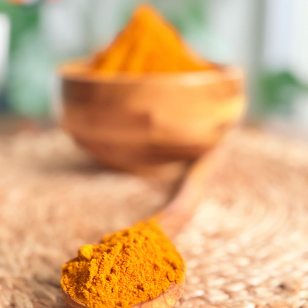 High-quality organic turmeric powder displayed on a white ceramic plate, showcasing its vibrant color and purity, sourced from organically grown turmeric roots.